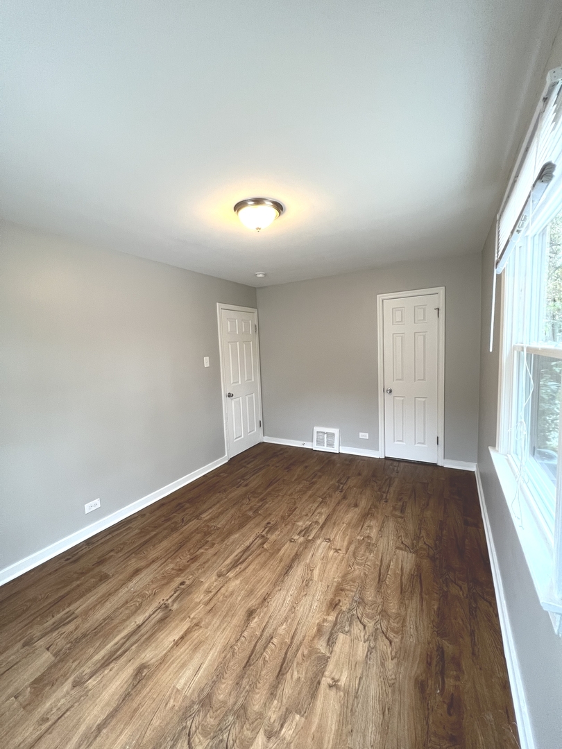 4409 Home Avenue Stickney, IL 60402 - Photo 16 of 21 an empty room with wooden floor and windows