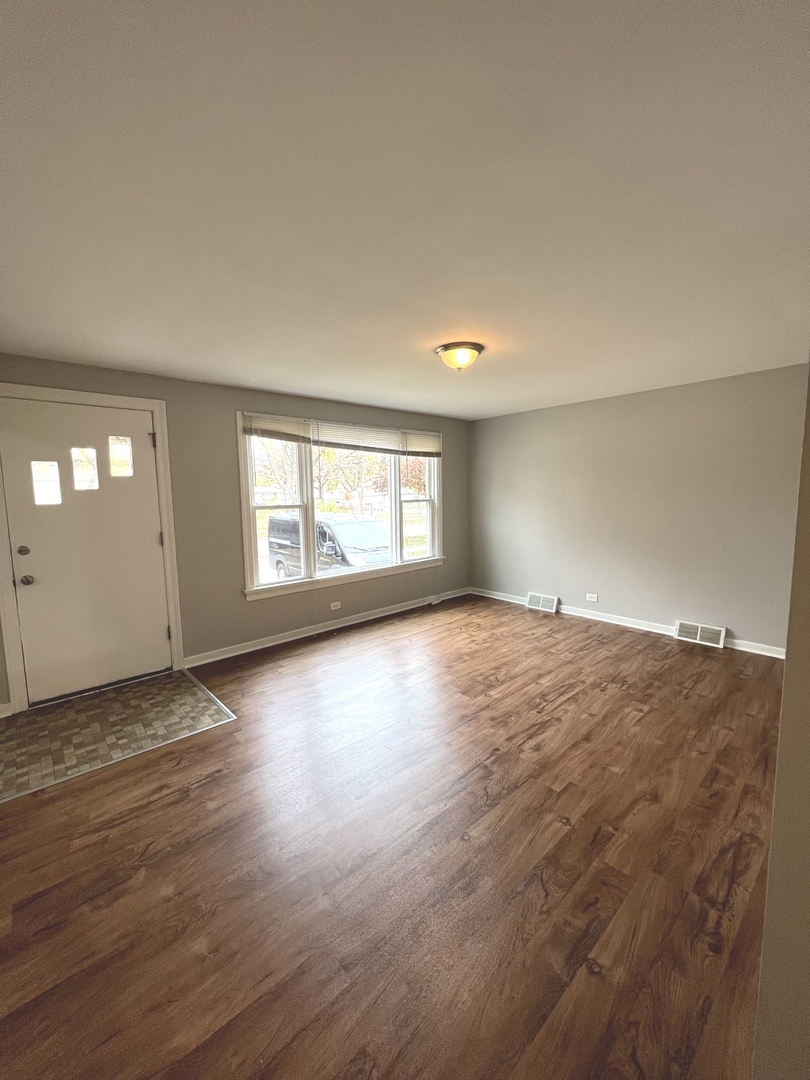 4409 Home Avenue Stickney, IL 60402 - Photo 3 of 21 an empty room with wooden floor and windows