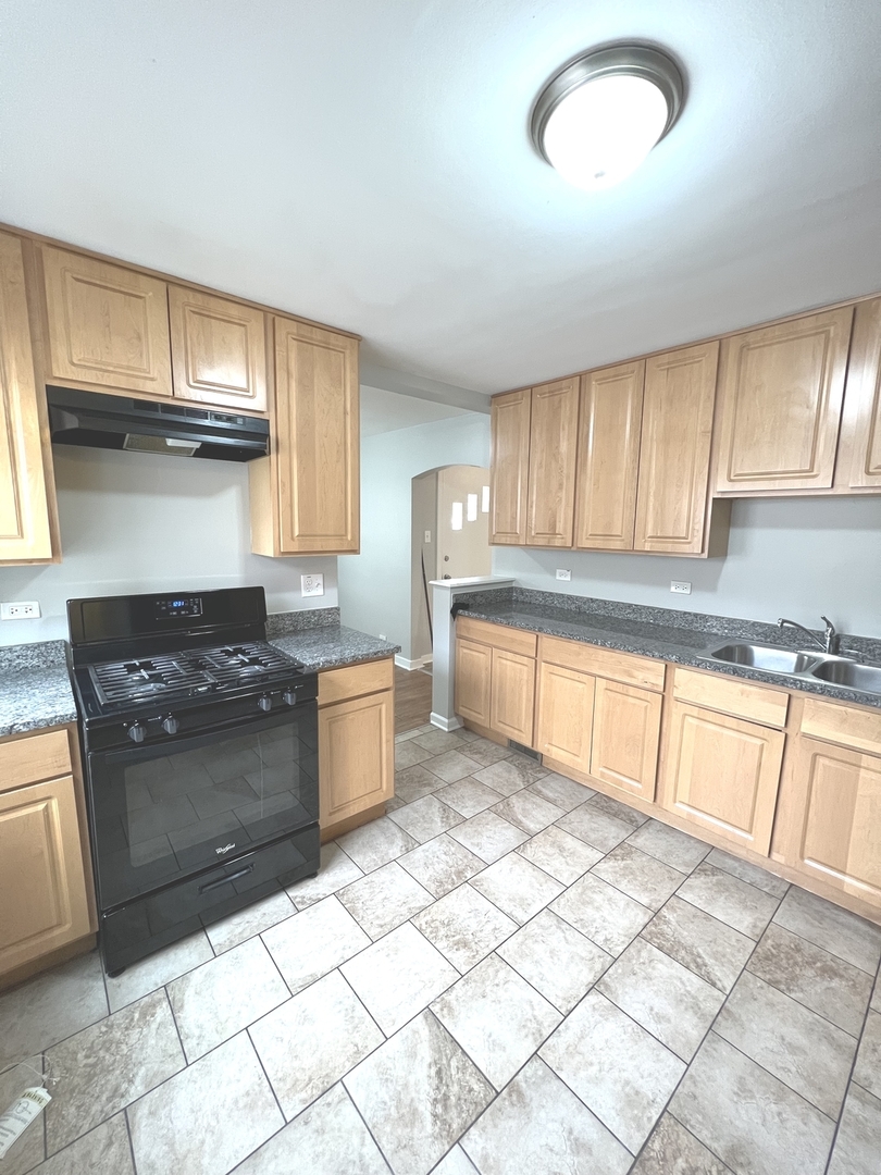 4409 Home Avenue Stickney, IL 60402 - Photo 6 of 21 a kitchen with stainless steel appliances granite countertop a stove a sink and a refrigerator