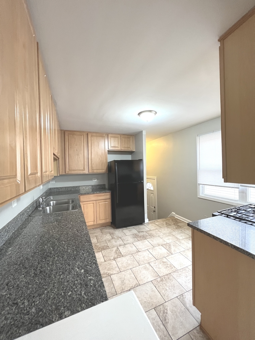 4409 Home Avenue Stickney, IL 60402 - Photo 8 of 21 a large kitchen with kitchen island granite countertop a sink and a stove top oven