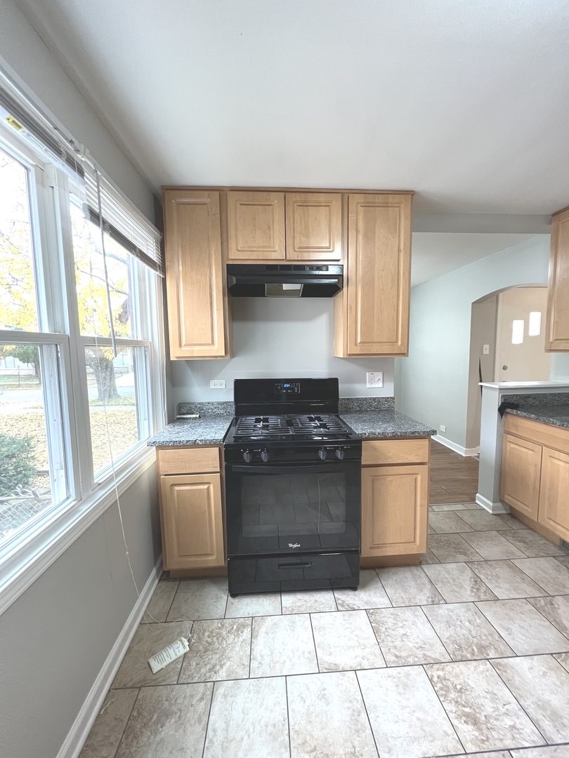 4409 Home Avenue Stickney, IL 60402 - Photo 9 of 21 a kitchen with granite countertop a stove a sink and a refrigerator