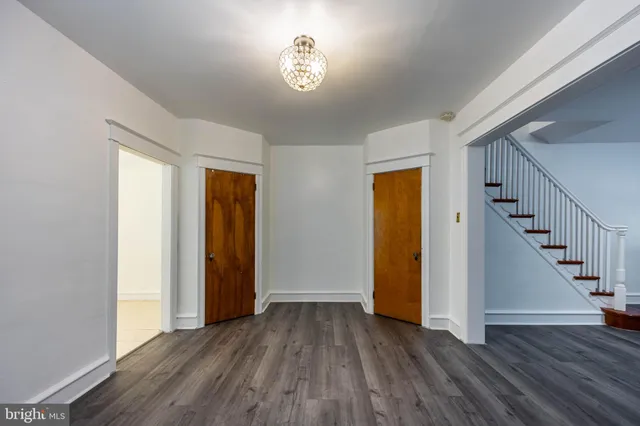 a view of empty room with wooden floor and stairs