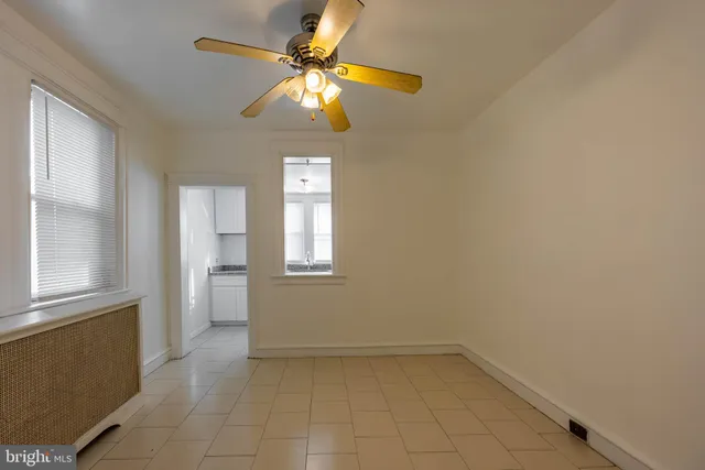 an empty room with windows and fan