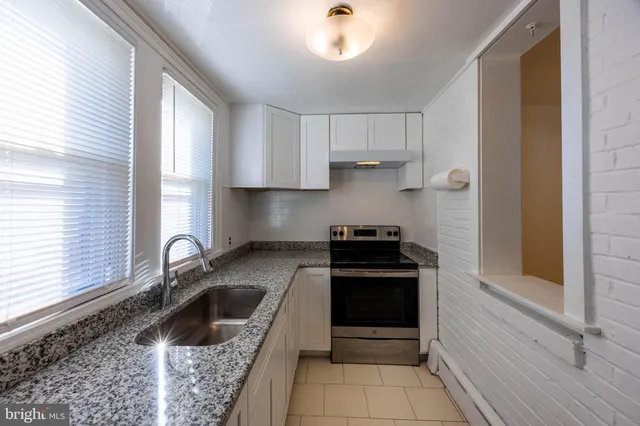 a kitchen with stainless steel appliances granite countertop a sink and a stove
