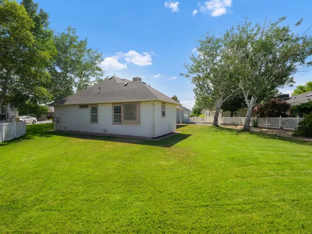 a view of a house with backyard and a tree