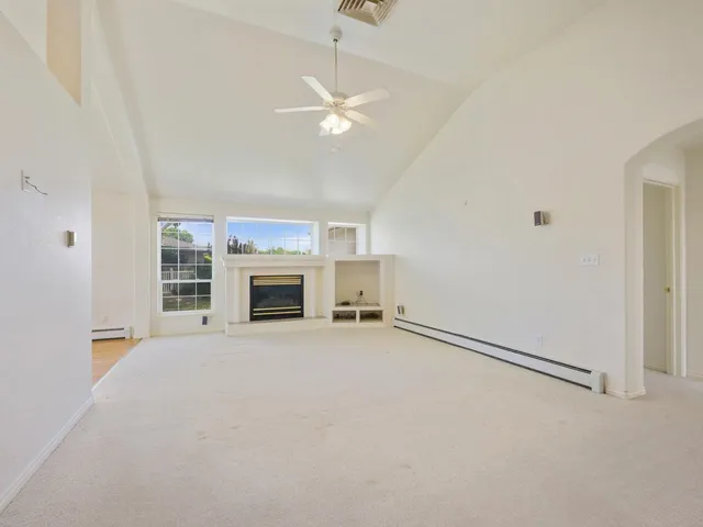 an empty room with fireplace and windows