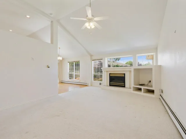 a view of a livingroom with a fireplace and a chandelier fan