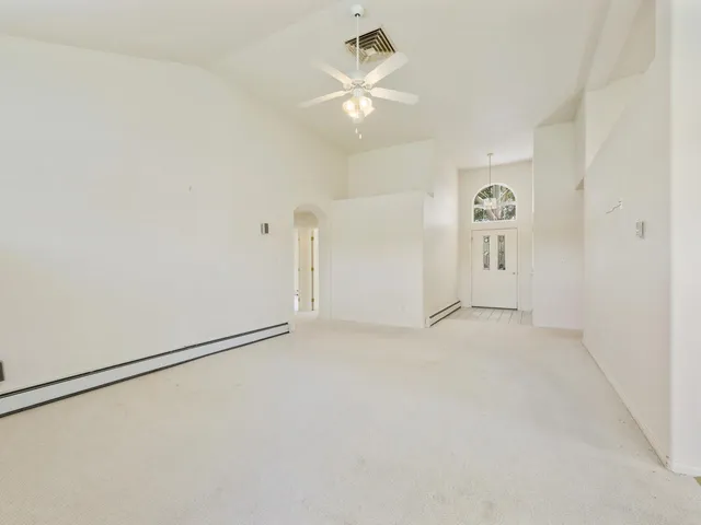 an empty room with a ceiling fan and a window