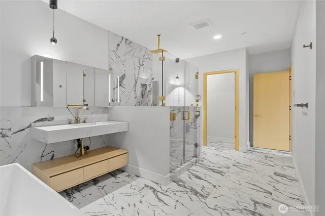 a bathroom with a sink a toilet and shower