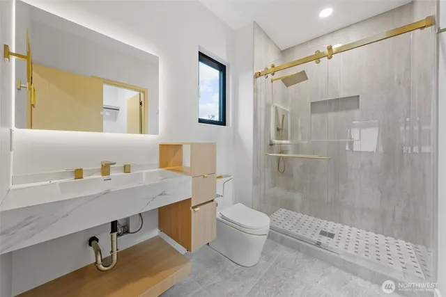 a bathroom with a sink a toilet and shower