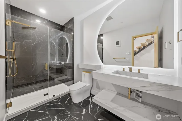 a bathroom with a double vanity sink toilet and shower