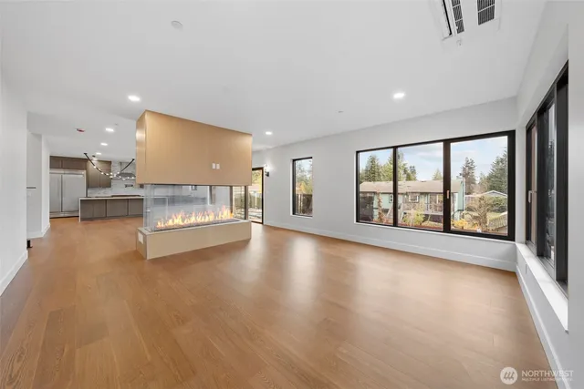 a view of empty room with wooden floor and fireplace