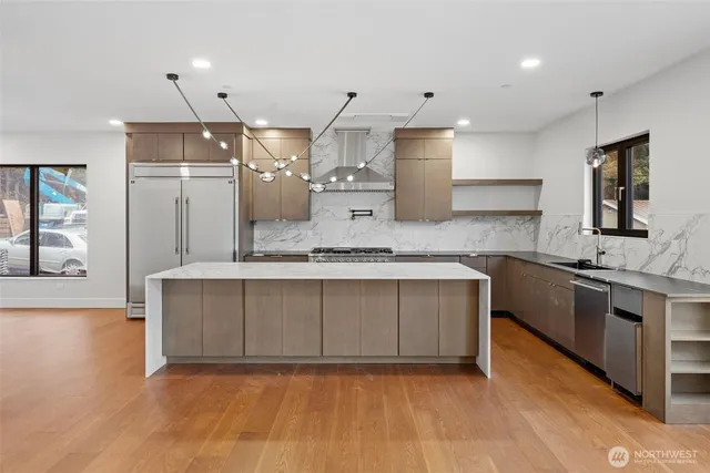 a large kitchen with stainless steel appliances kitchen island granite countertop a stove a sink dishwasher and a refrigerator