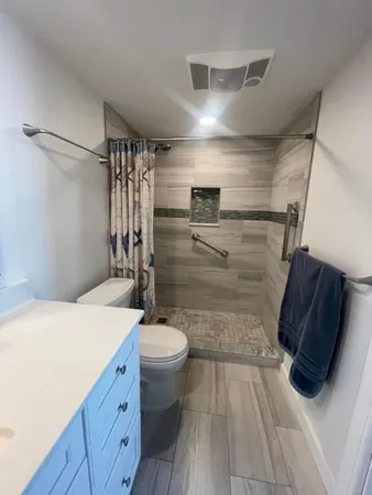 a bathroom with a sink a toilet and shower
