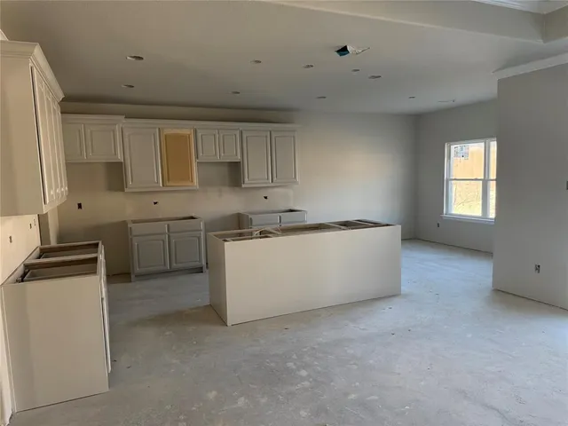 a kitchen with white cabinets and white appliances