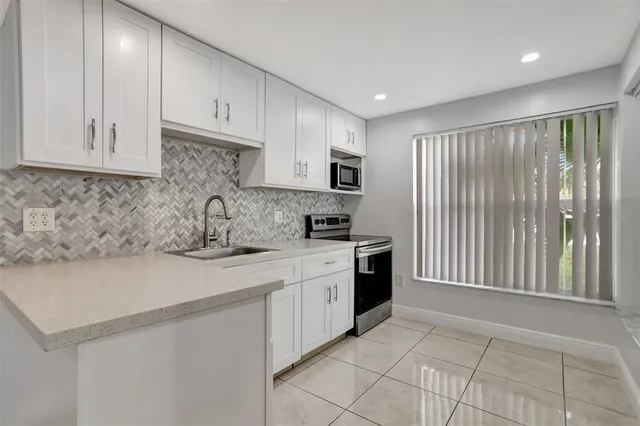 a kitchen with a refrigerator a sink and a window