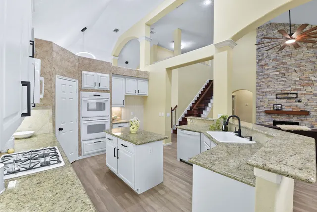 a kitchen with stainless steel appliances granite countertop a sink stove and refrigerator
