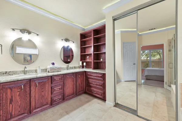 a en suite bathroom with a granite countertop sink and mirror