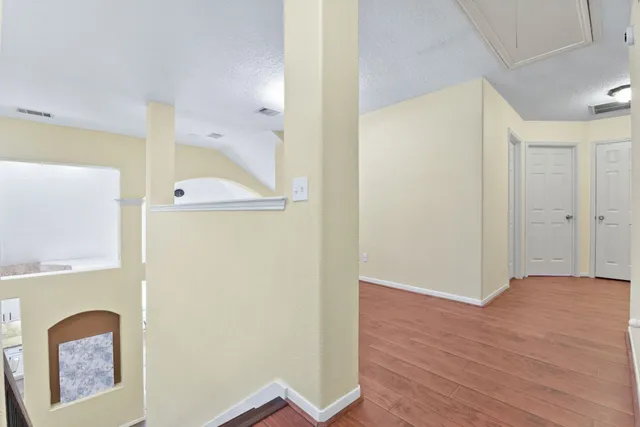 a view of a hallway with wooden floor
