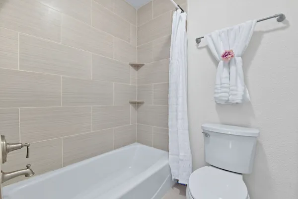 a white toilet sitting next to a bath tub