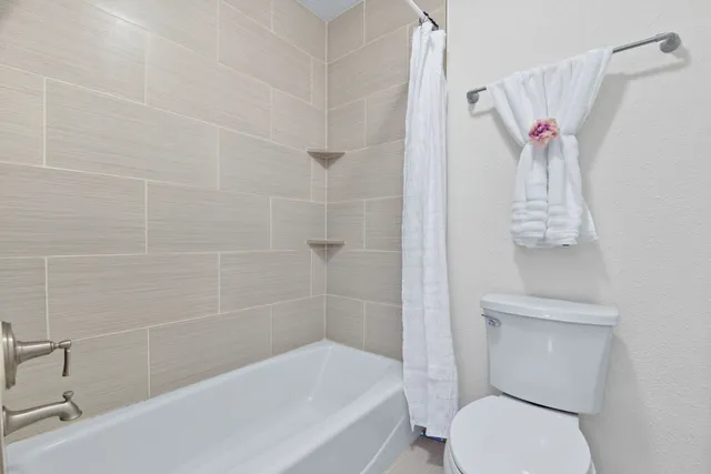 a white toilet sitting next to a bath tub