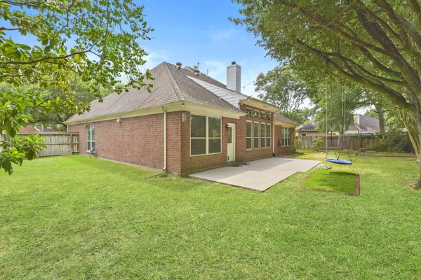 a view of a house with a backyard and a tree
