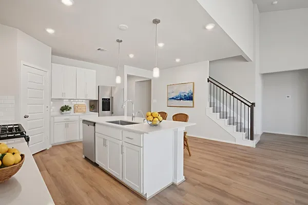 a kitchen with white cabinets sink and stove