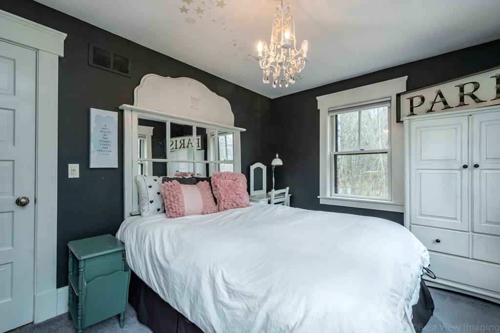 25 Crockett Road Upton, MA 01568 - Photo 32 of 39 a bedroom with a large bed and a chandelier