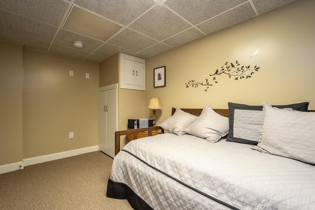 25 Crockett Road Upton, MA 01568 - Photo 36 of 39 a bedroom with a bed and a chandelier