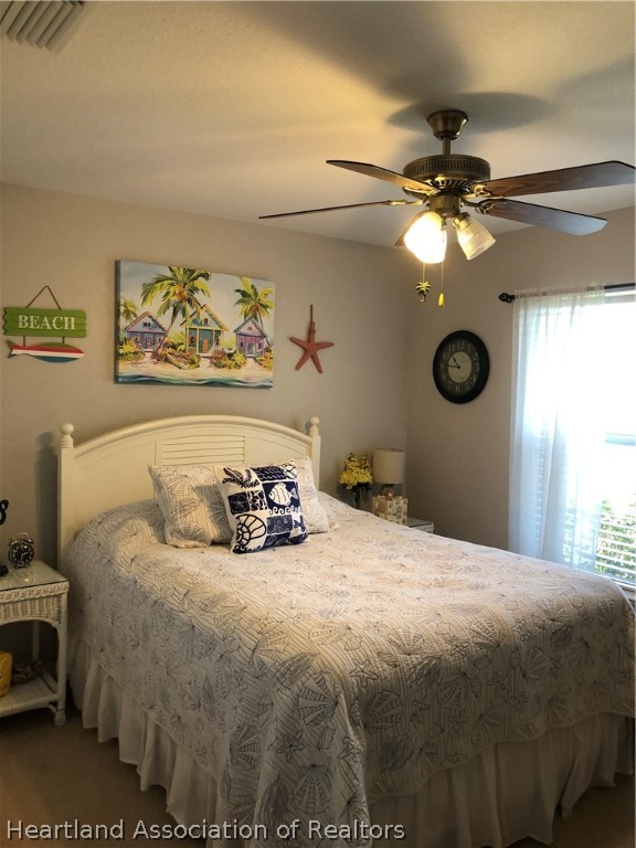 1208 Lakeside Way Sebring, FL 33875 - Photo 15 of 29 a bedroom with a bed and a chandelier
