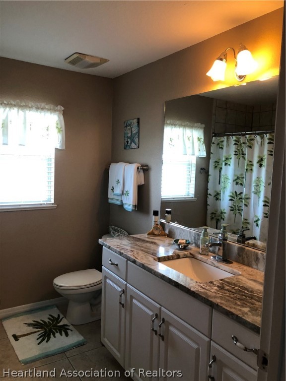 1208 Lakeside Way Sebring, FL 33875 - Photo 16 of 29 a bathroom with a sink a toilet a mirror and a window