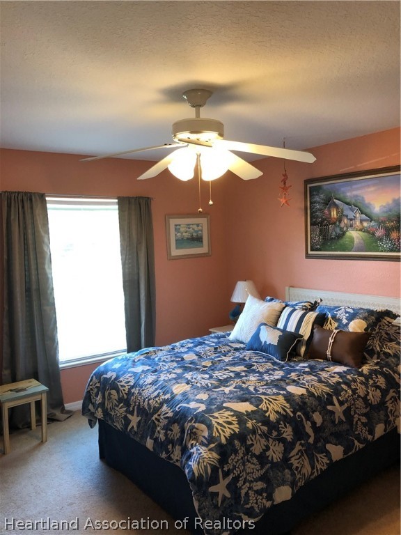 1208 Lakeside Way Sebring, FL 33875 - Photo 17 of 29 a bedroom with a bed and a chandelier