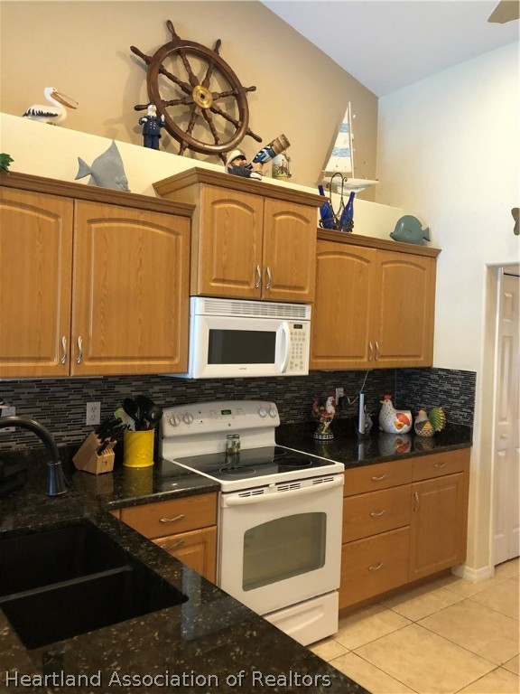 1208 Lakeside Way Sebring, FL 33875 - Photo 4 of 29 a kitchen with stainless steel appliances granite countertop a stove a sink and a microwave