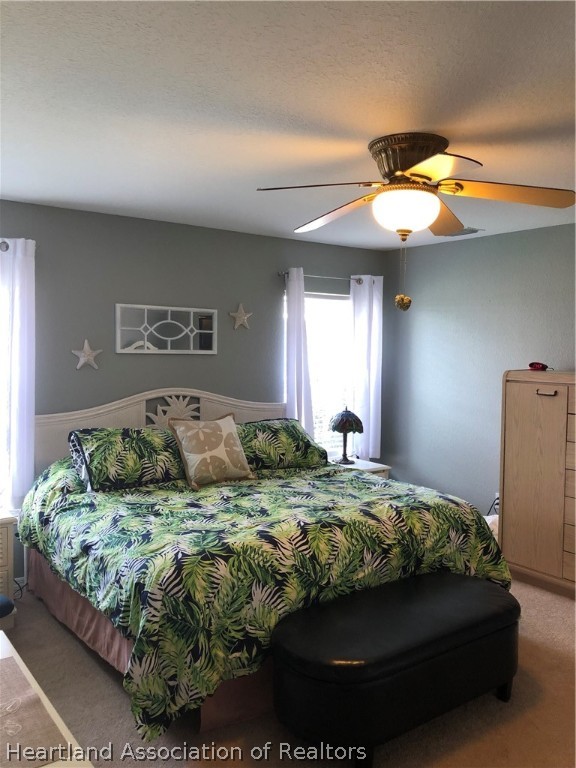 1208 Lakeside Way Sebring, FL 33875 - Photo 8 of 29 a bedroom with a bed and a chandelier