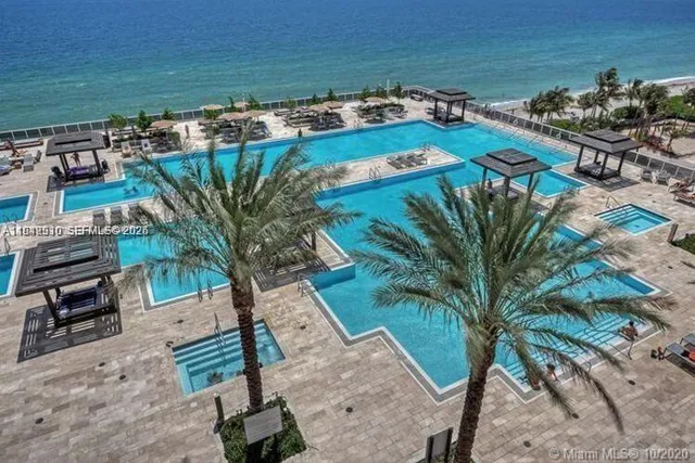 a view of a backyard with plants and ocean view