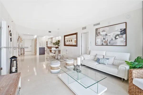 a living room with furniture a rug and white walls
