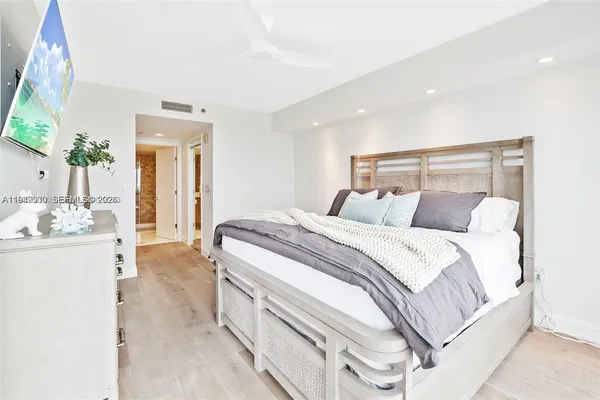 a spacious bedroom with a bed and a mirror