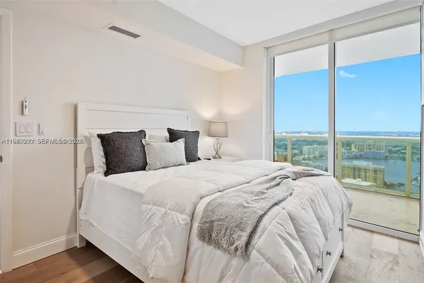 a large bed sitting in a bedroom next to a window