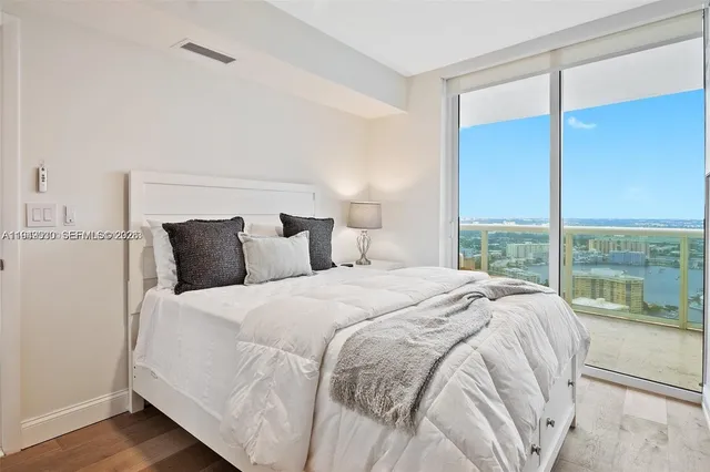 a large bed sitting in a bedroom next to a window