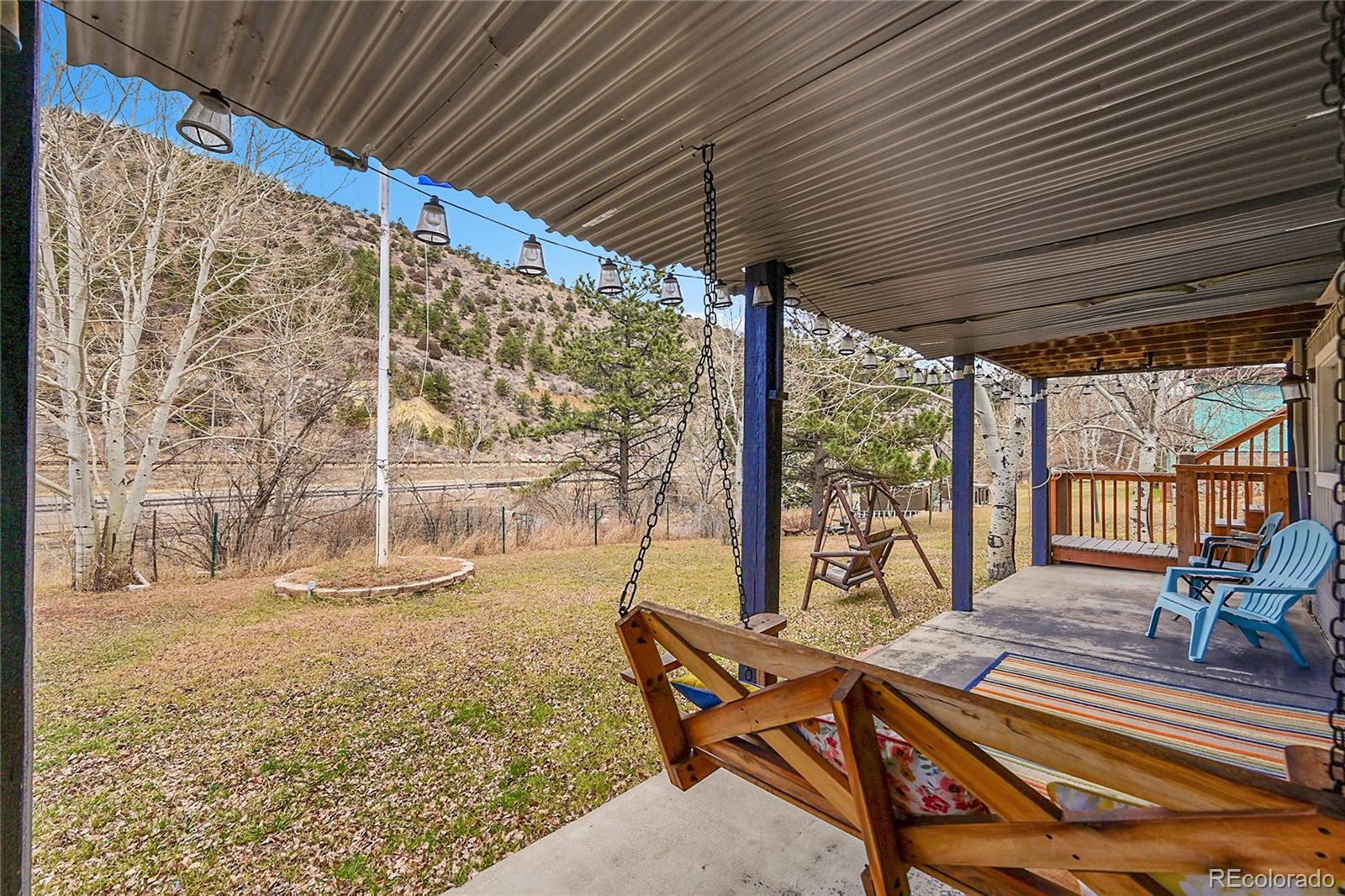 3645 Stanley Road Dumont, CO 80436 - Photo 29 of 39 a view of a patio with table and chairs next to a large window with wooden floor