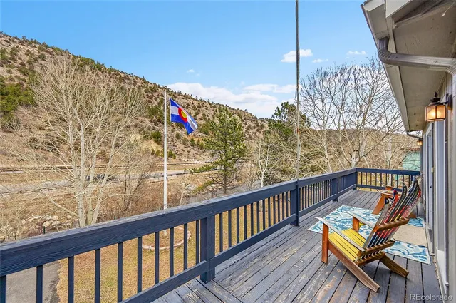 a view of a patio with table and chairs next to a large window with wooden floor