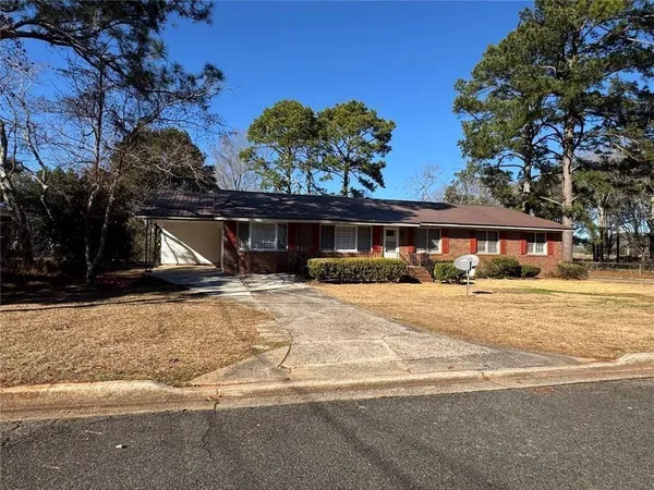 a front view of a house with a yard and tree s