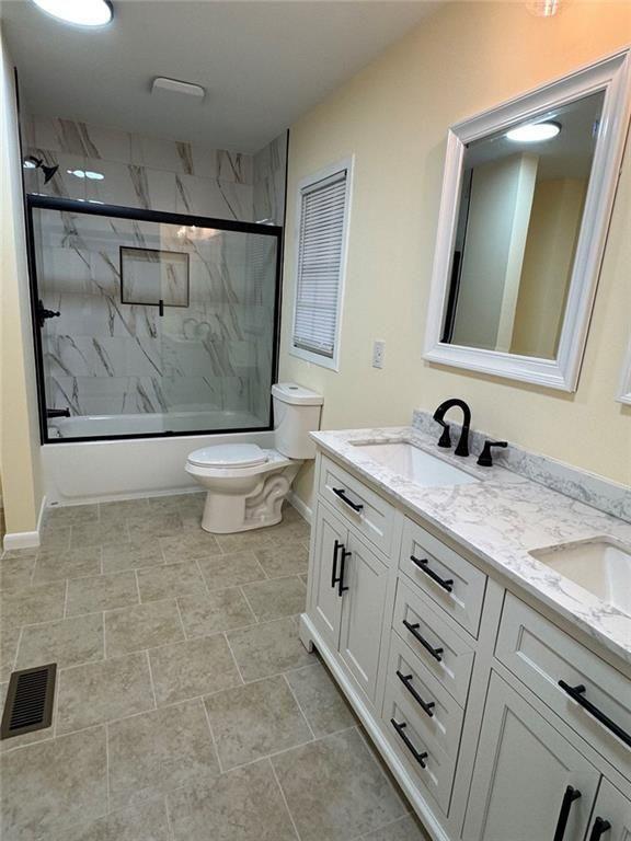 202 Lawn Street Fort Valley, GA 31030 - Photo 2 of 7 a bathroom with a granite countertop sink a toilet a mirror and shower