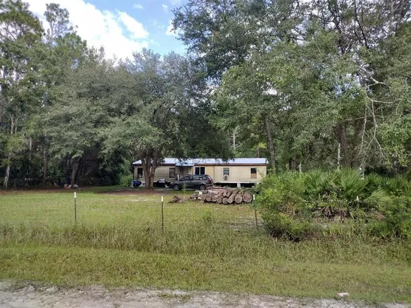 a view of a house with a backyard