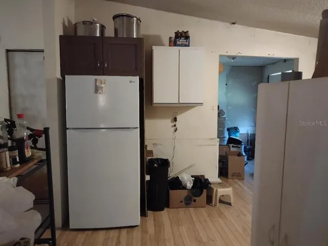 a view of workspace with wooden floor and a refrigerator