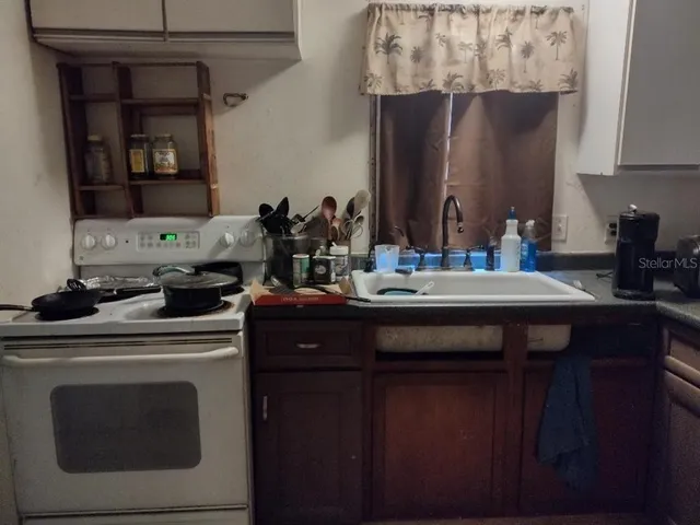 a kitchen with a sink cabinets and wooden floor