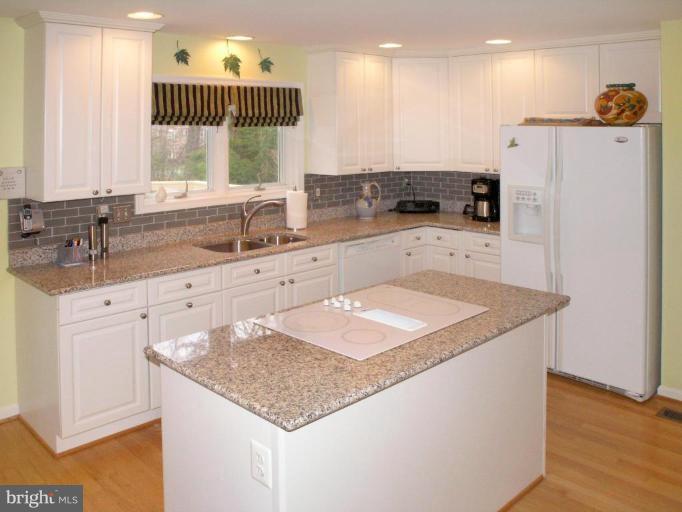 11200 Center Post Court Reston, VA 20194 - Photo 9 of 30 a kitchen with granite countertop a sink stainless steel appliances and white cabinets
