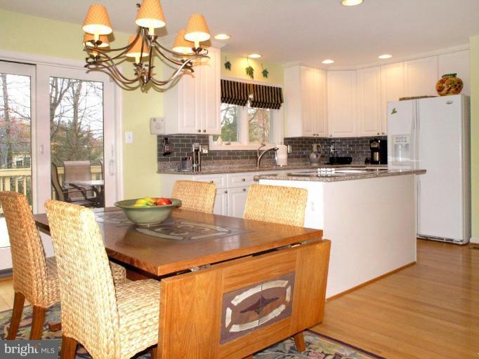 11200 Center Post Court Reston, VA 20194 - Photo 10 of 30 a kitchen with kitchen island a stove a sink a refrigerator and wooden floor