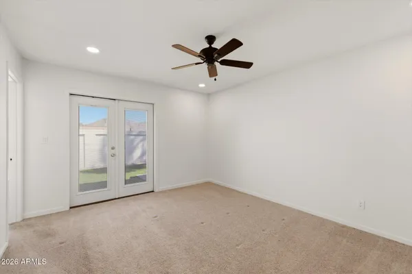 an empty room with windows and fan