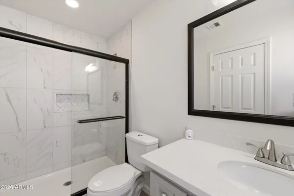 a bathroom with a sink toilet vanity and shower